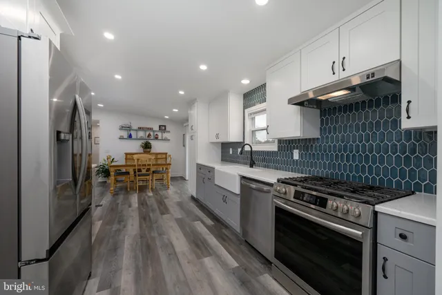 a kitchen with stainless steel appliances a stove a sink and a refrigerator