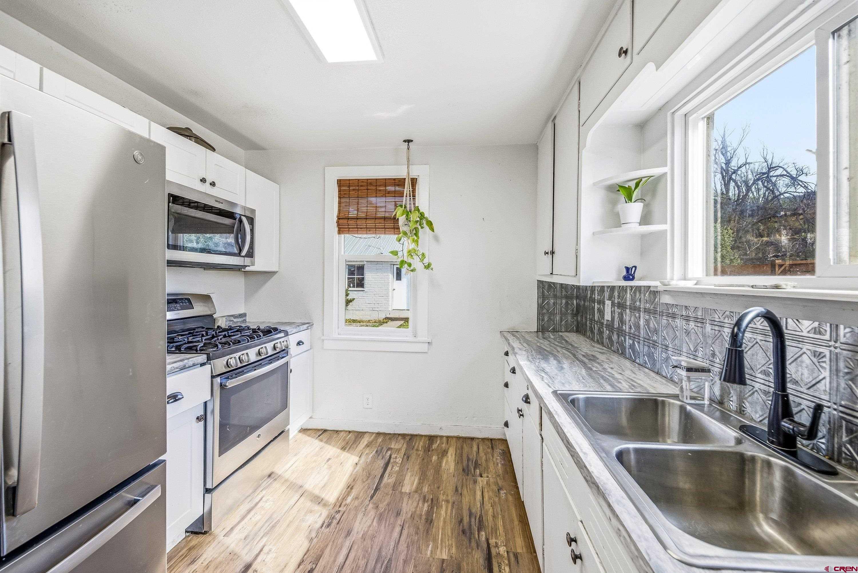 325 East 3rd Street Delta, CO 81416 - Photo 8 of 23 a kitchen with a sink stove and refrigerator