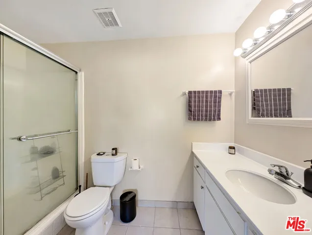 a bathroom with a granite countertop sink toilet a mirror and shower