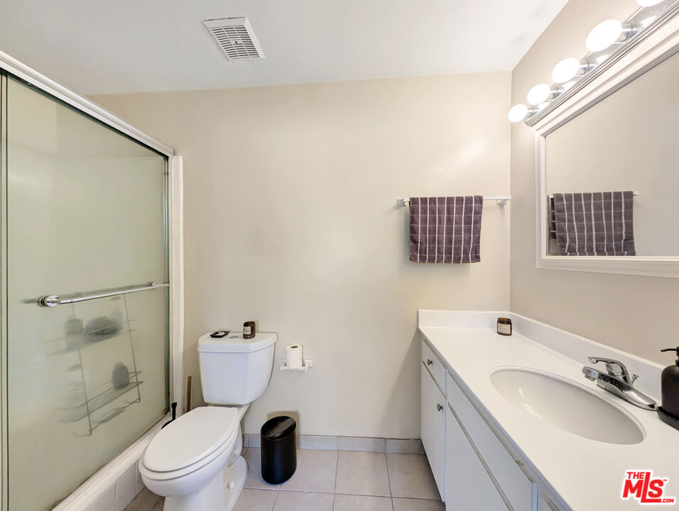 440 Raymond Avenue, Unit 1 Santa Monica, CA 90405 - Photo 12 of 14 a bathroom with a granite countertop sink toilet a mirror and shower