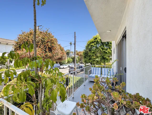 a view of a porch with chairs and potted plants