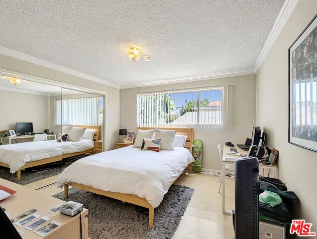 a bedroom with two beds and a large window