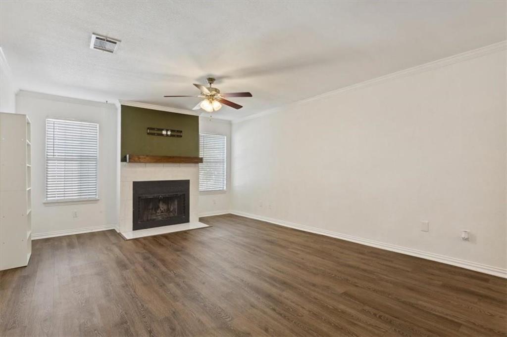 2306 Melissa Drive Waco, TX 76708 - Photo 6 of 22 a view of a livingroom with a fireplace a ceiling fan and wooden floor