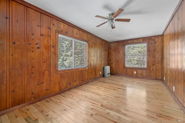 a view of an empty room with a window and a ceiling fan