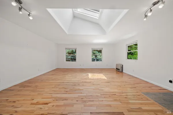 a view of empty room with wooden floor