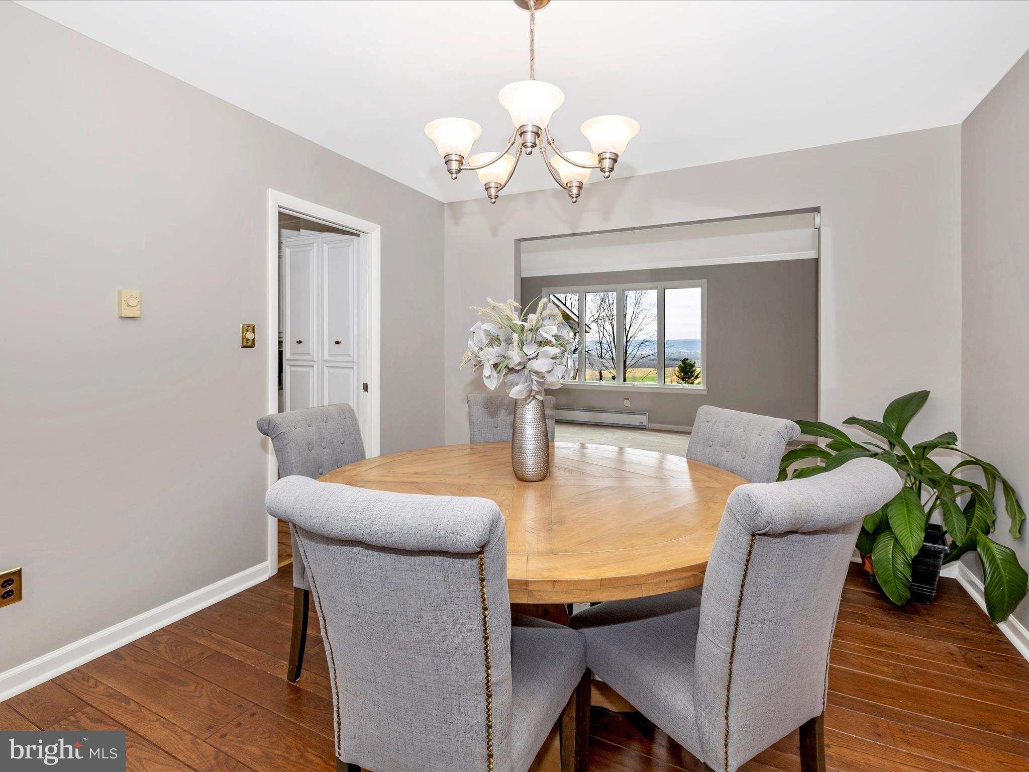 4426 Teen Barnes Road Frederick, MD 21703 - Photo 14 of 76 a dining room with wooden floor a chandelier a glass table and chairs