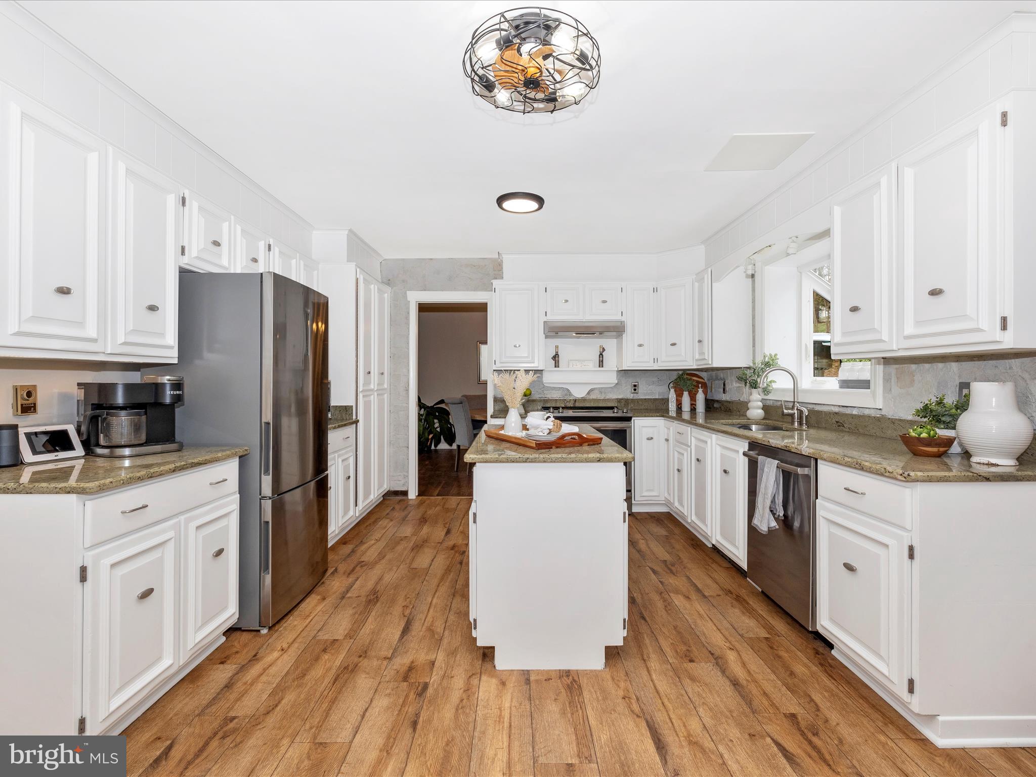 4426 Teen Barnes Road Frederick, MD 21703 - Photo 17 of 76 a kitchen with stainless steel appliances a stove top oven a refrigerator a sink dishwasher and white cabinets with wooden floor