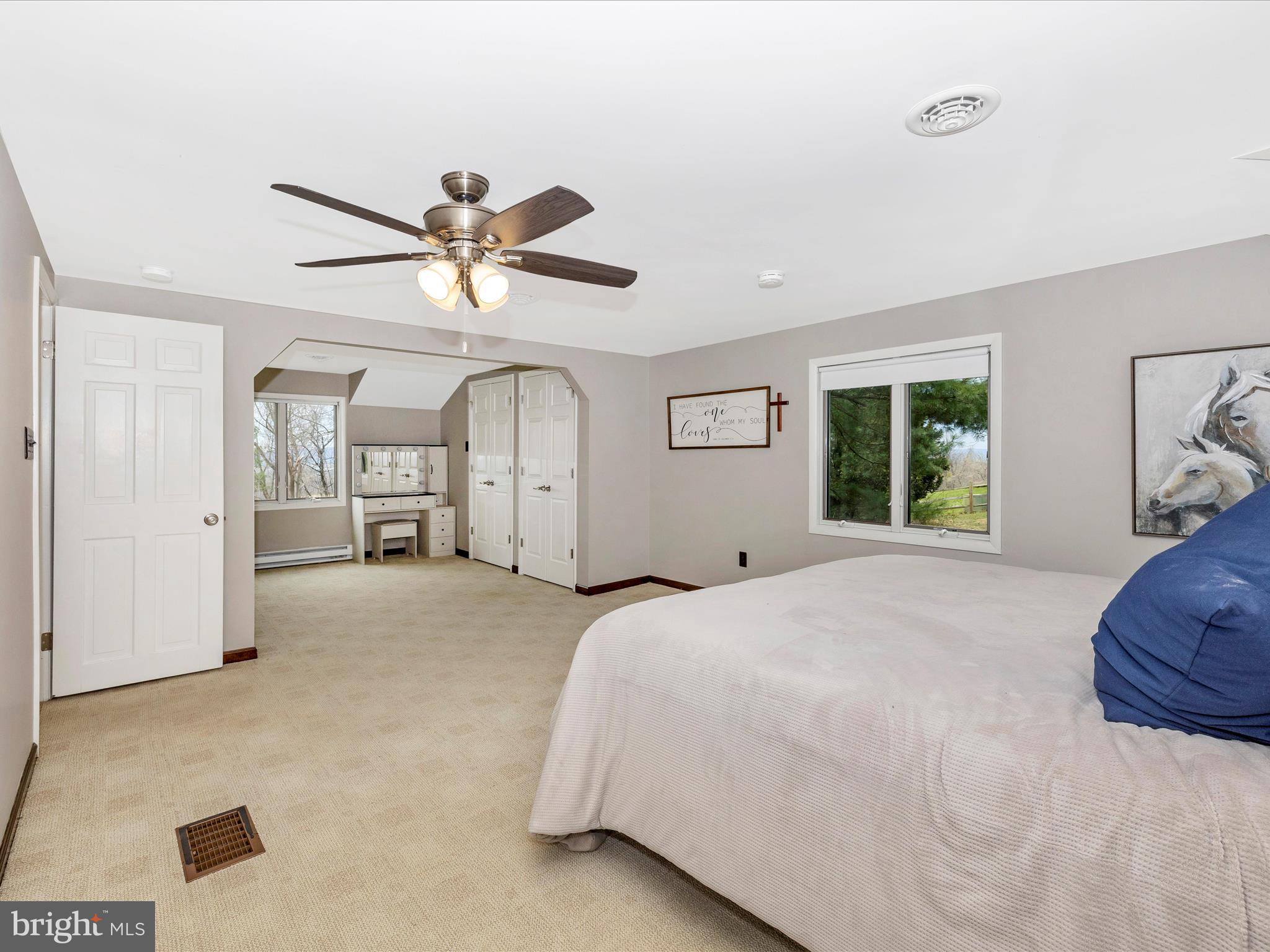 4426 Teen Barnes Road Frederick, MD 21703 - Photo 34 of 76 a spacious bedroom with a large bed a chandelier and window