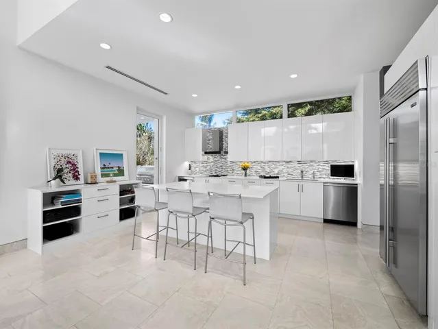 a large white kitchen with a stove top oven