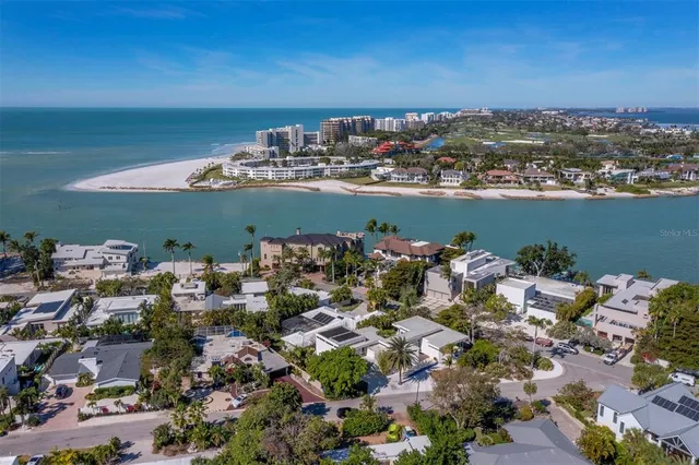 an aerial view of ocean and residential houses with outdoor space