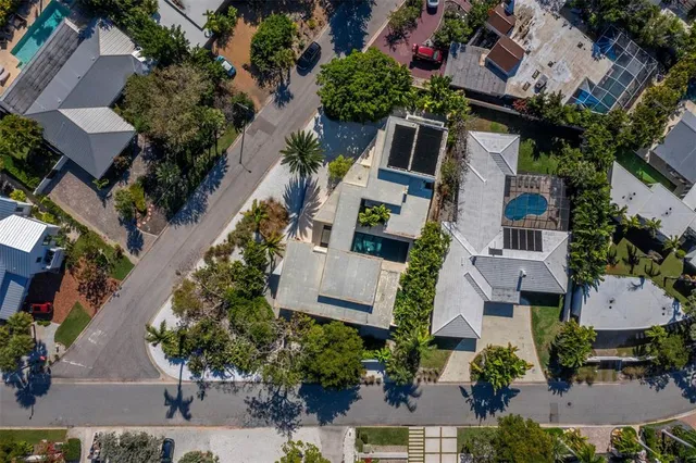 an aerial view of a city with lots of residential buildings and ocean view in back