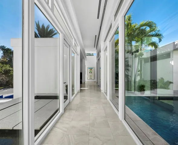 a living room with furniture a clock and a large window