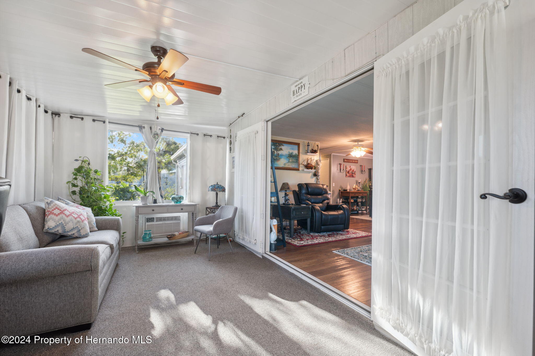 15116 Rialto Avenue Brooksville, FL 34613 - Photo 12 of 36 a living room with furniture and a large window with garden view