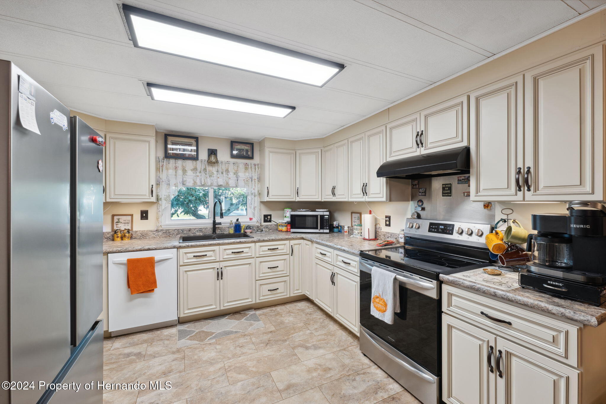 15116 Rialto Avenue Brooksville, FL 34613 - Photo 19 of 36 a kitchen with stainless steel appliances granite countertop a sink a stove and refrigerator