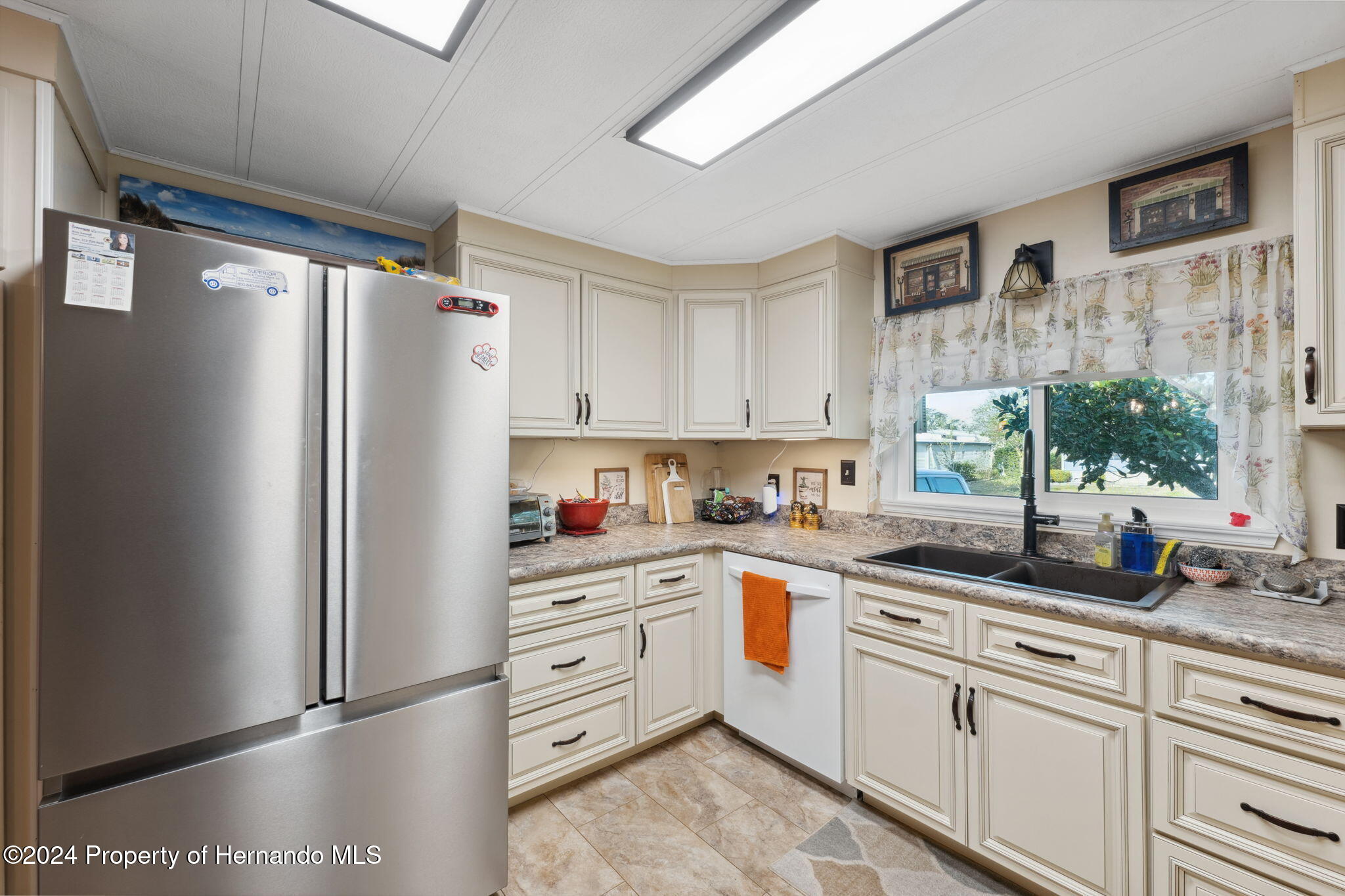 15116 Rialto Avenue Brooksville, FL 34613 - Photo 21 of 36 a kitchen with stainless steel appliances a refrigerator sink and cabinets