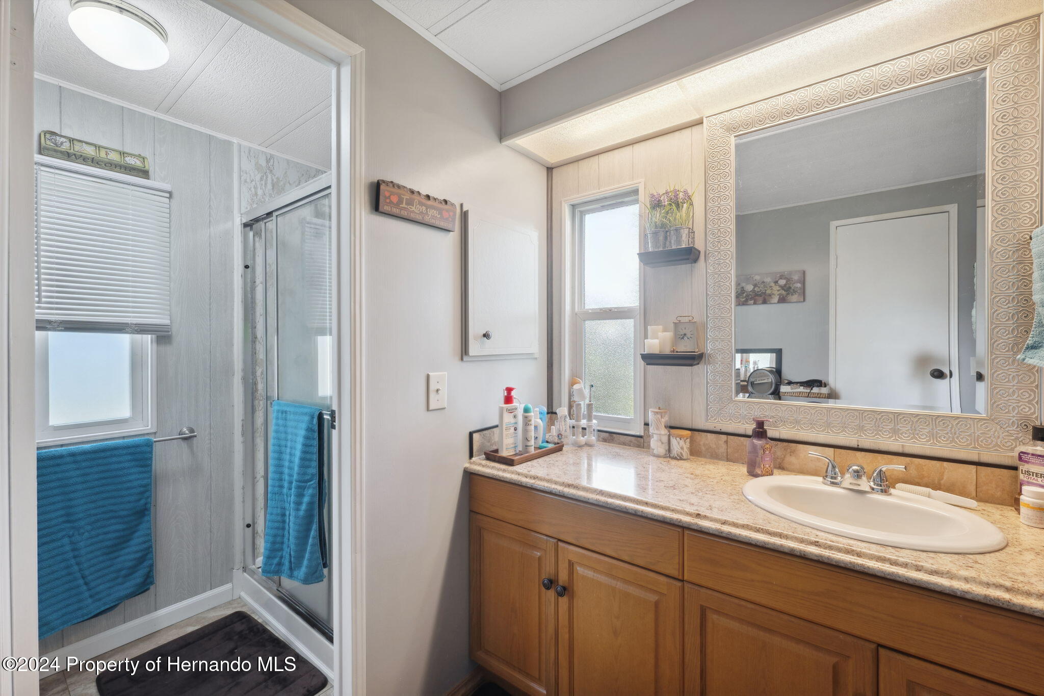 15116 Rialto Avenue Brooksville, FL 34613 - Photo 24 of 36 a bathroom with a double vanity sink and mirror