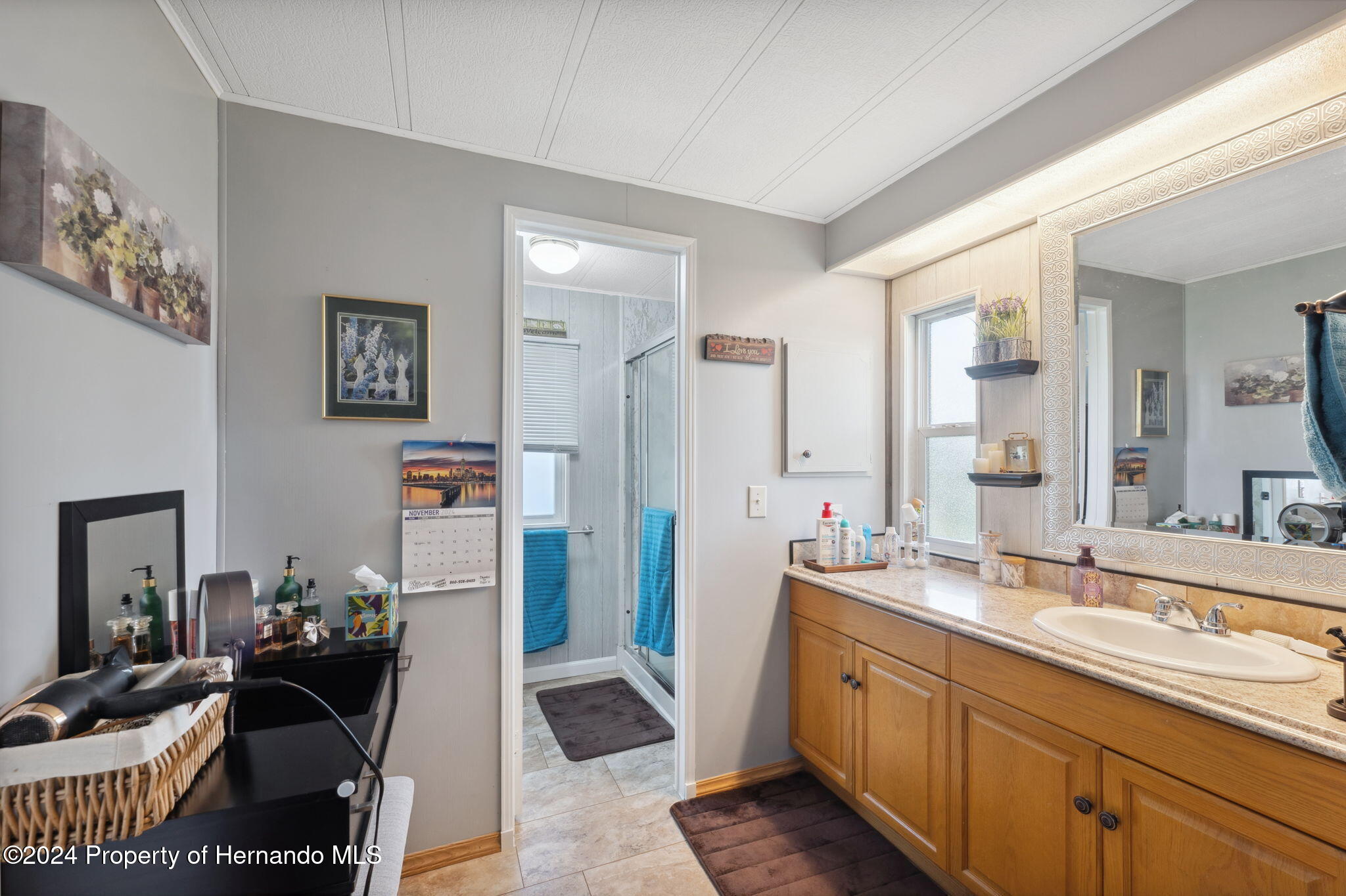 15116 Rialto Avenue Brooksville, FL 34613 - Photo 26 of 36 a spacious bathroom with a double vanity sink and a mirror