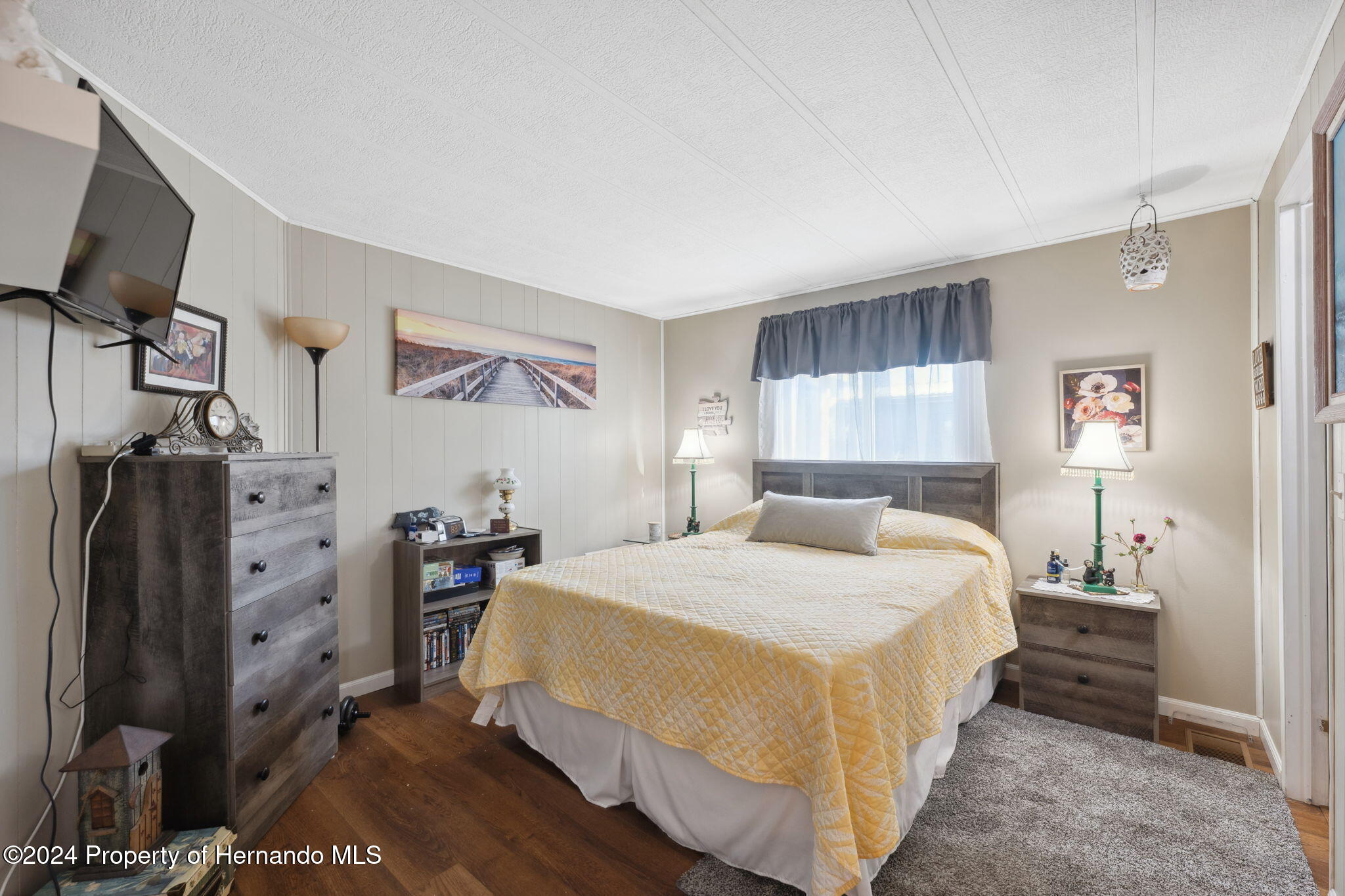 15116 Rialto Avenue Brooksville, FL 34613 - Photo 29 of 36 a bedroom with a bed and a flat tv screen