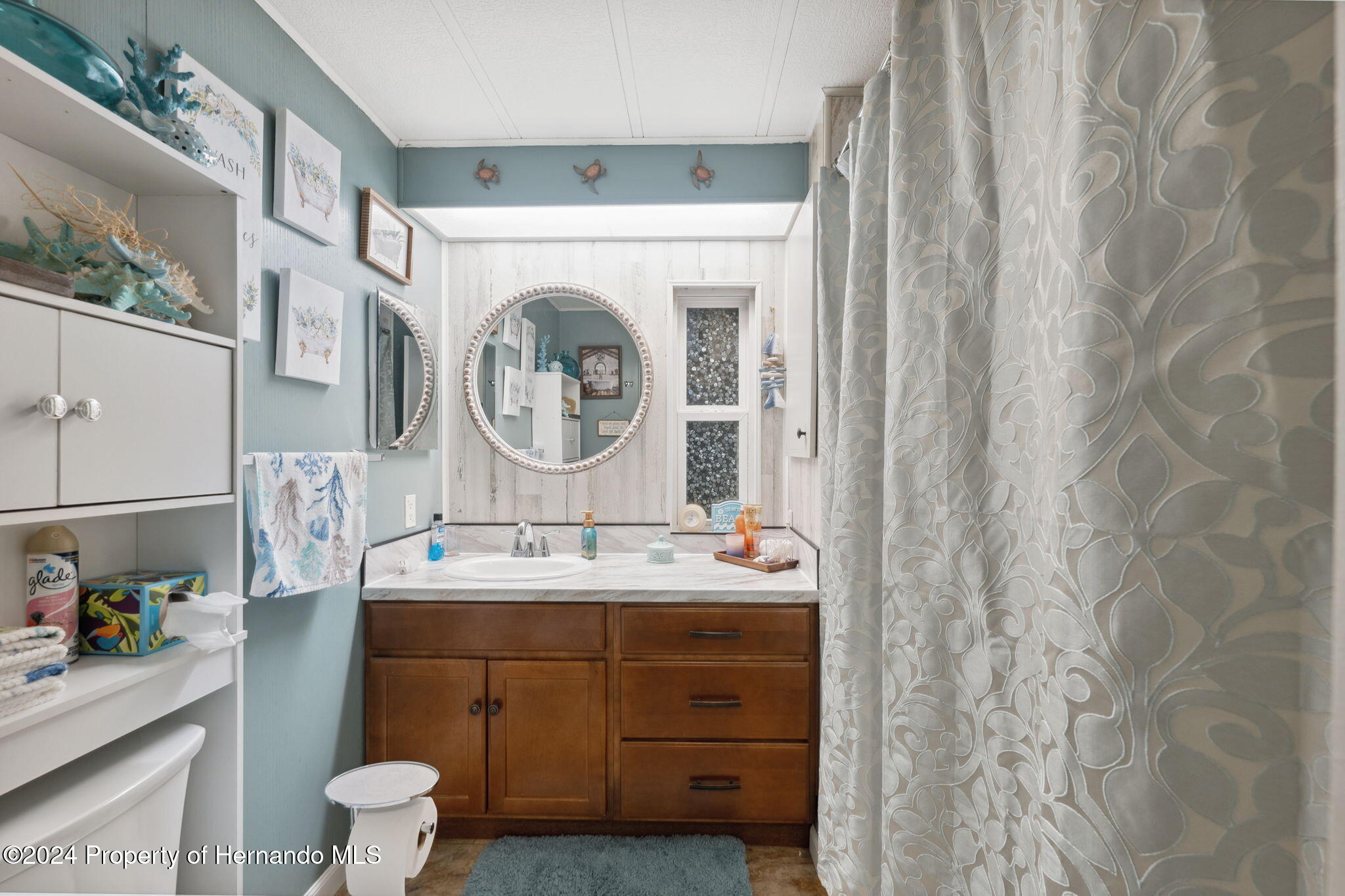 15116 Rialto Avenue Brooksville, FL 34613 - Photo 31 of 36 a bathroom with a sink a toilet and a mirror