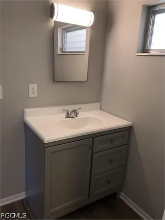 a sink sitting under a bathroom mirror