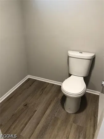 a white toilet sitting next to a wooden cabinet