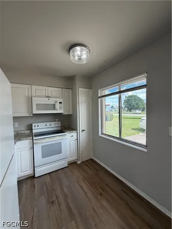 a kitchen with granite countertop a stove and a large window