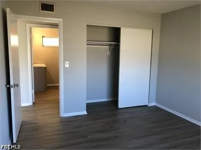 a view of empty room with wooden floor and closet