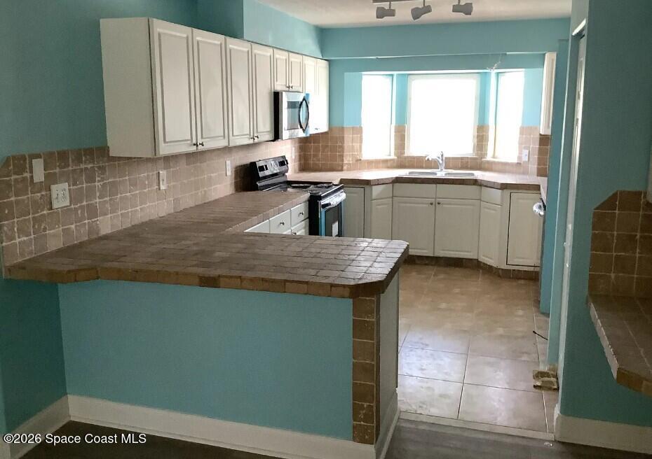 180 Richards Road Melbourne Beach, FL 32951 - Photo 14 of 32 a kitchen with a sink cabinets and window