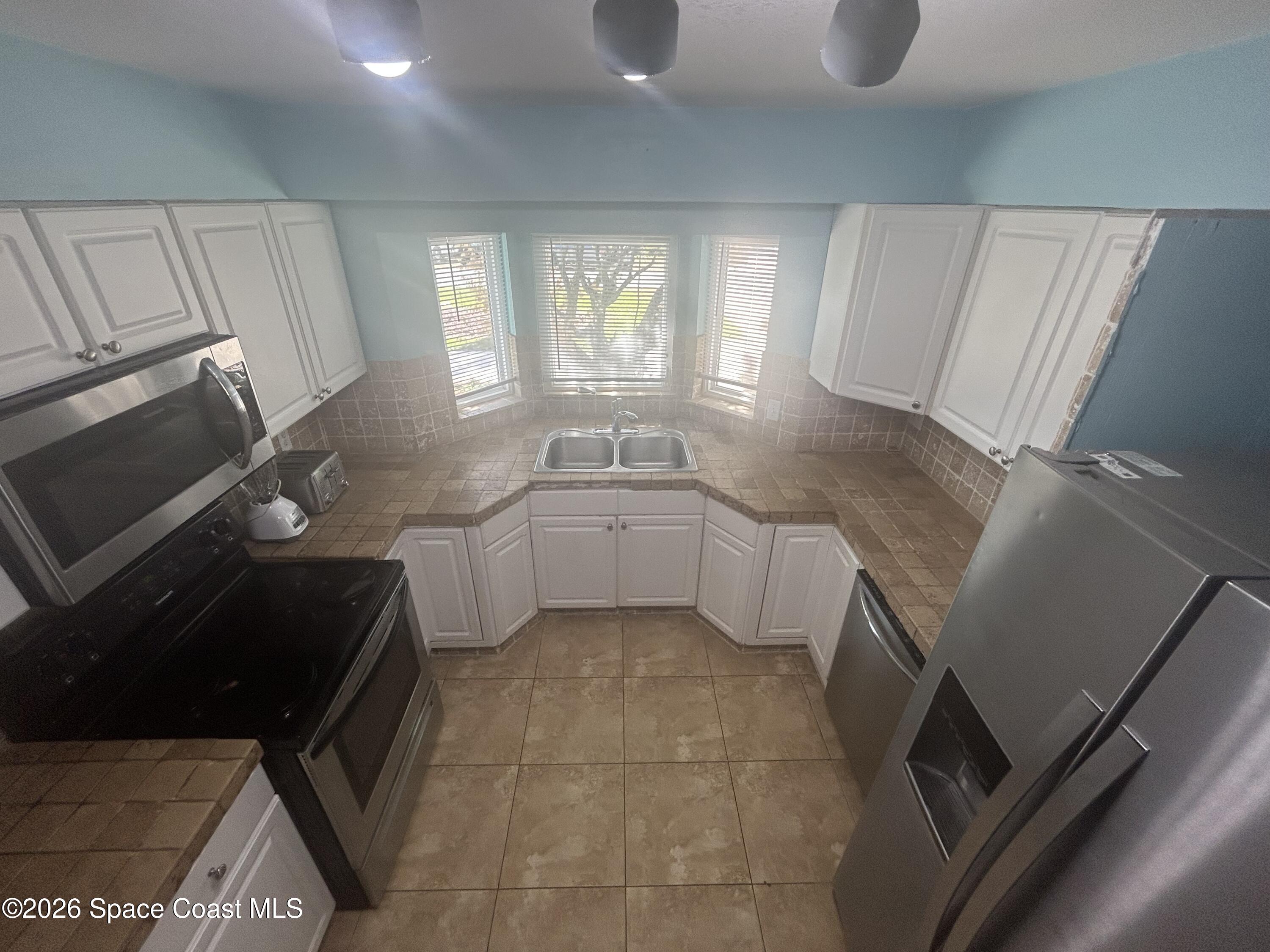 180 Richards Road Melbourne Beach, FL 32951 - Photo 15 of 32 a kitchen with a sink a stove and cabinets