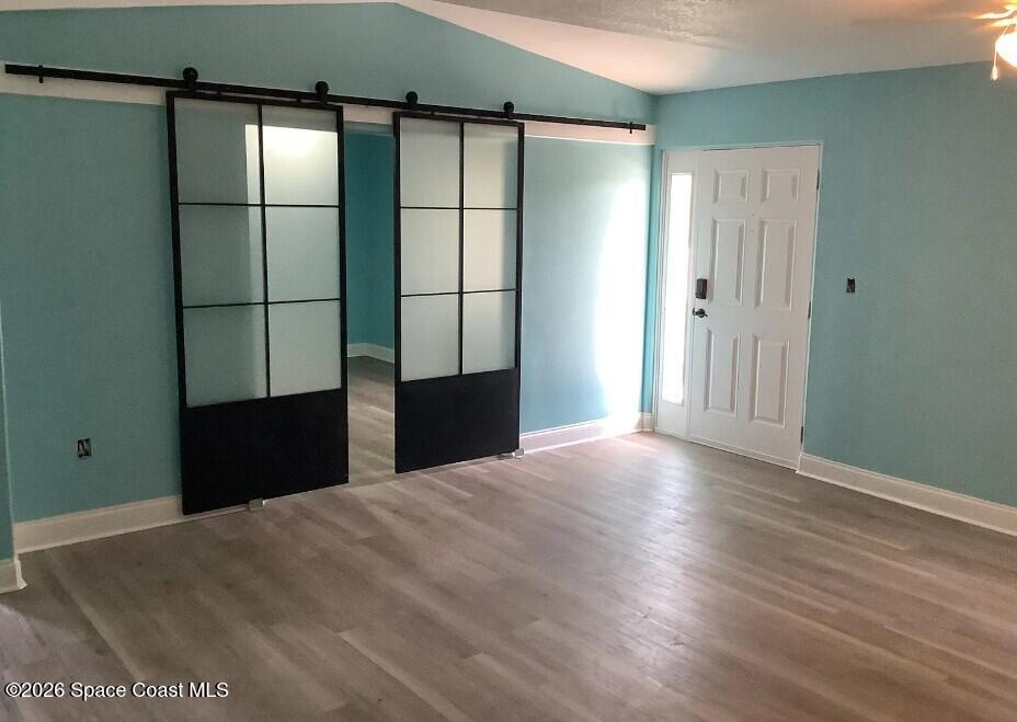 180 Richards Road Melbourne Beach, FL 32951 - Photo 2 of 32 a view of an empty room with wooden floor and a window