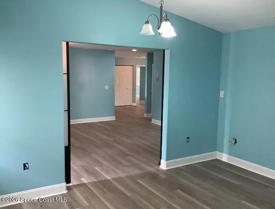 180 Richards Road Melbourne Beach, FL 32951 - Photo 5 of 32 an empty room with wooden floor and chandelier
