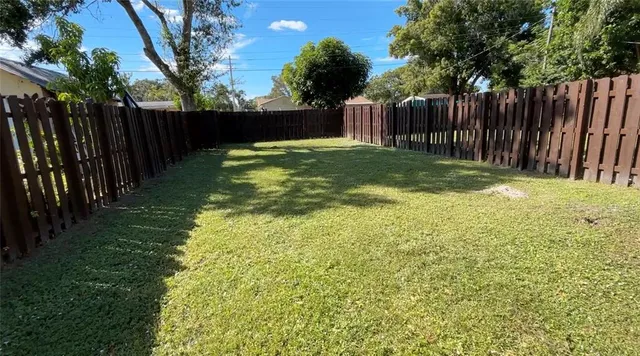a view of a yard with wooden fence