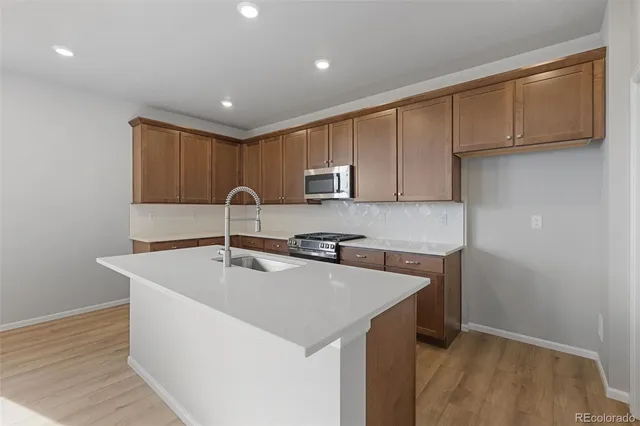 a kitchen with a sink a stove and cabinets