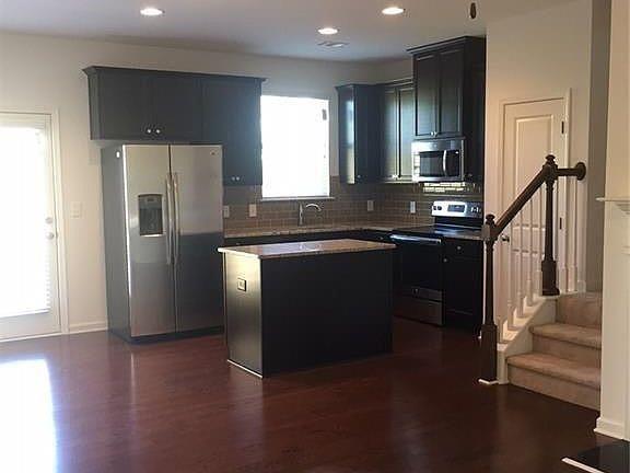 2701 Avanti Way Decatur, GA 30035 - Photo 2 of 3 a kitchen with stainless steel appliances granite countertop a refrigerator a sink and a stove with wooden floor