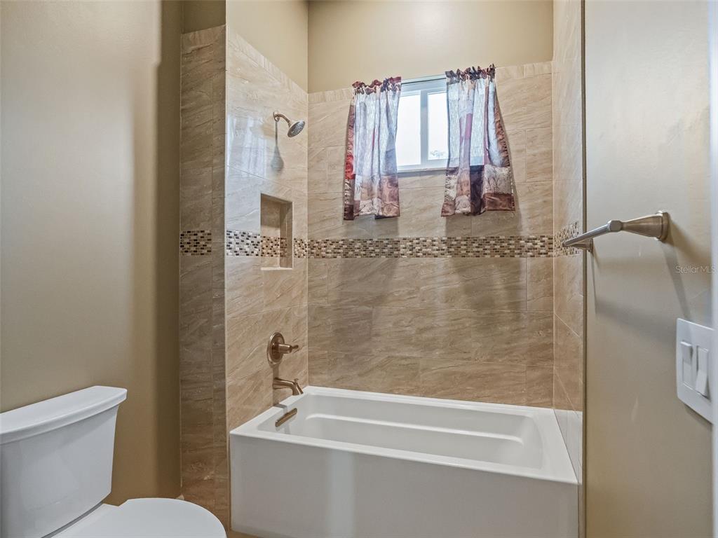 7549 Northwest 33rd Place Ocala, FL 34482 - Photo 44 of 83 a bathroom with a granite countertop bathtub shower sink and toilet