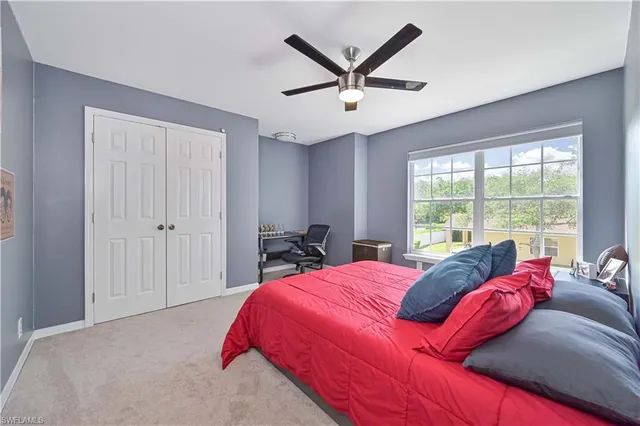 a bedroom with a bed a dresser and a chandelier