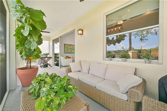 a view of a bench in a yard with potted plants and trees