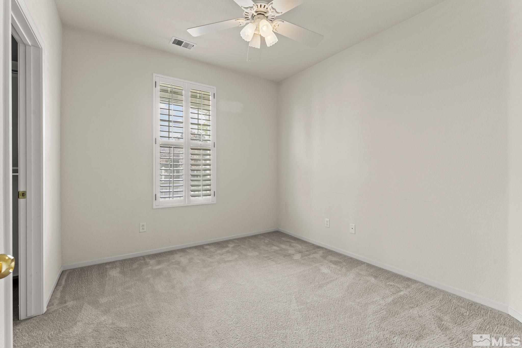 1436 Gaucho Lane Reno, NV 89521 - Photo 12 of 40 an empty room with a window and a ceiling fan