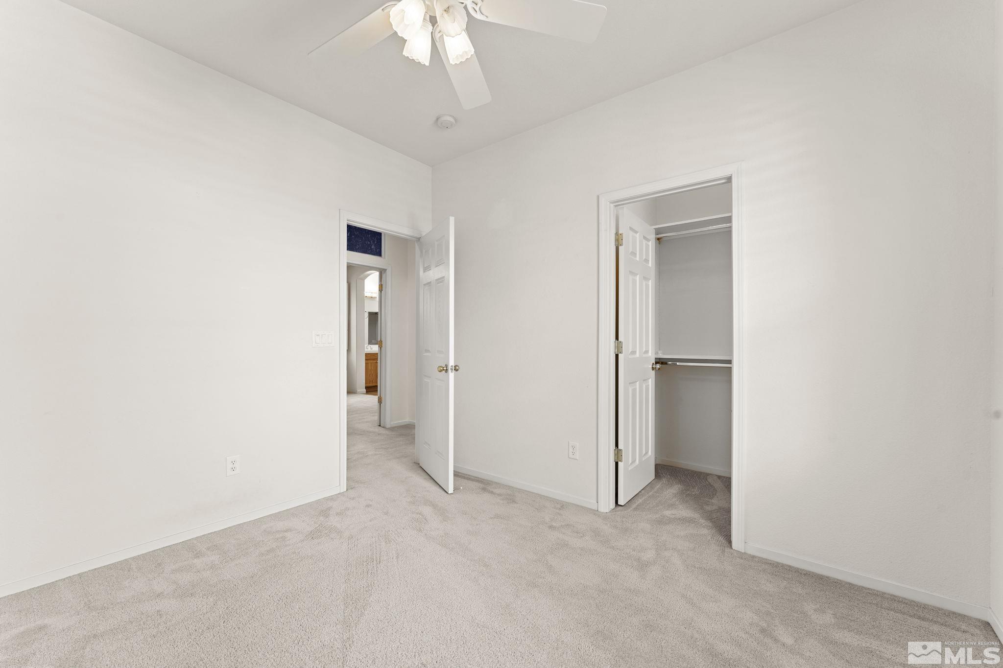 1436 Gaucho Lane Reno, NV 89521 - Photo 13 of 40 an empty room with a fan and a chandelier fan