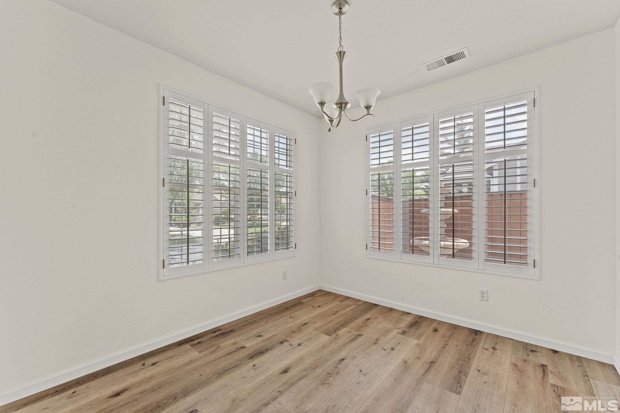 1436 Gaucho Lane Reno, NV 89521 - Photo 22 of 40 a view of an empty room with wooden floor and a window