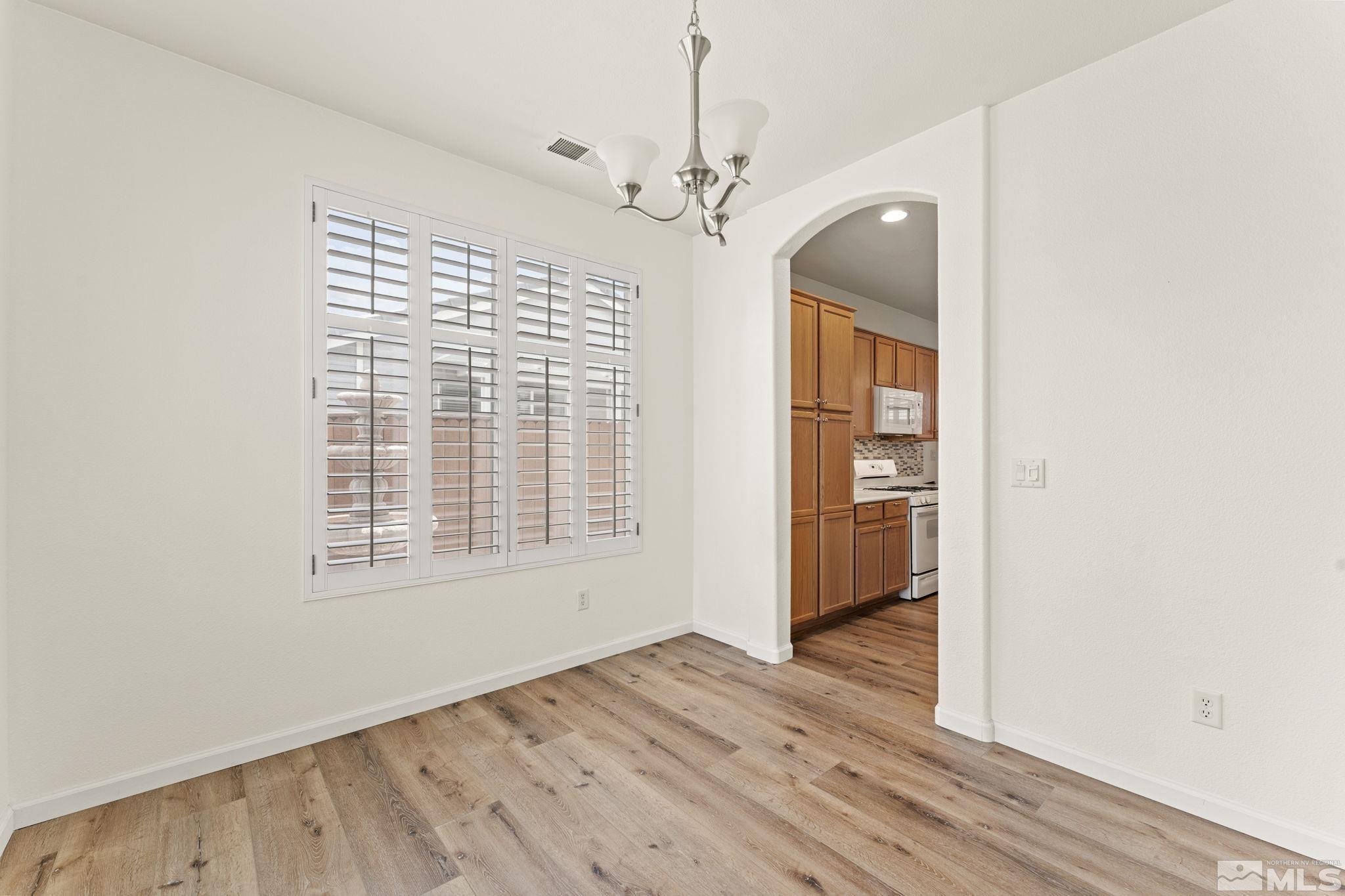 1436 Gaucho Lane Reno, NV 89521 - Photo 23 of 40 a view of an empty room with a window and wooden floor
