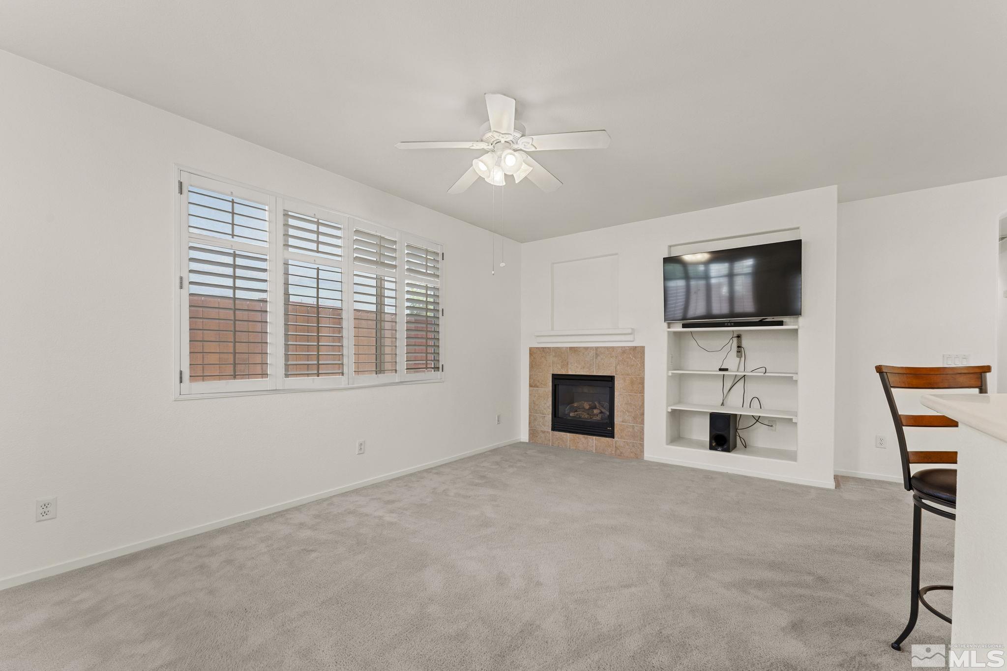 1436 Gaucho Lane Reno, NV 89521 - Photo 27 of 40 a view of a livingroom with a fireplace a ceiling fan and windows