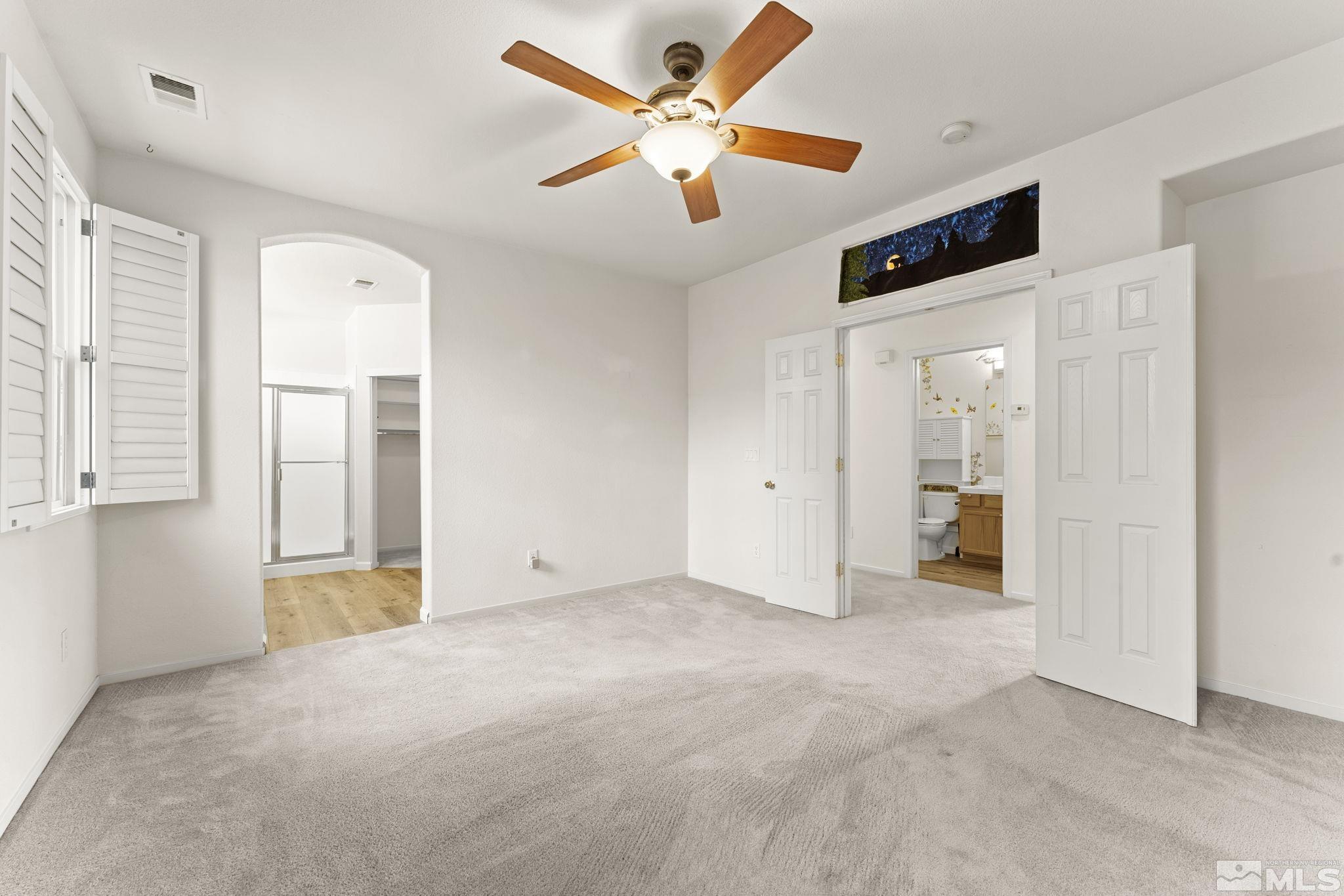 1436 Gaucho Lane Reno, NV 89521 - Photo 8 of 40 an empty room with chandelier fan and windows