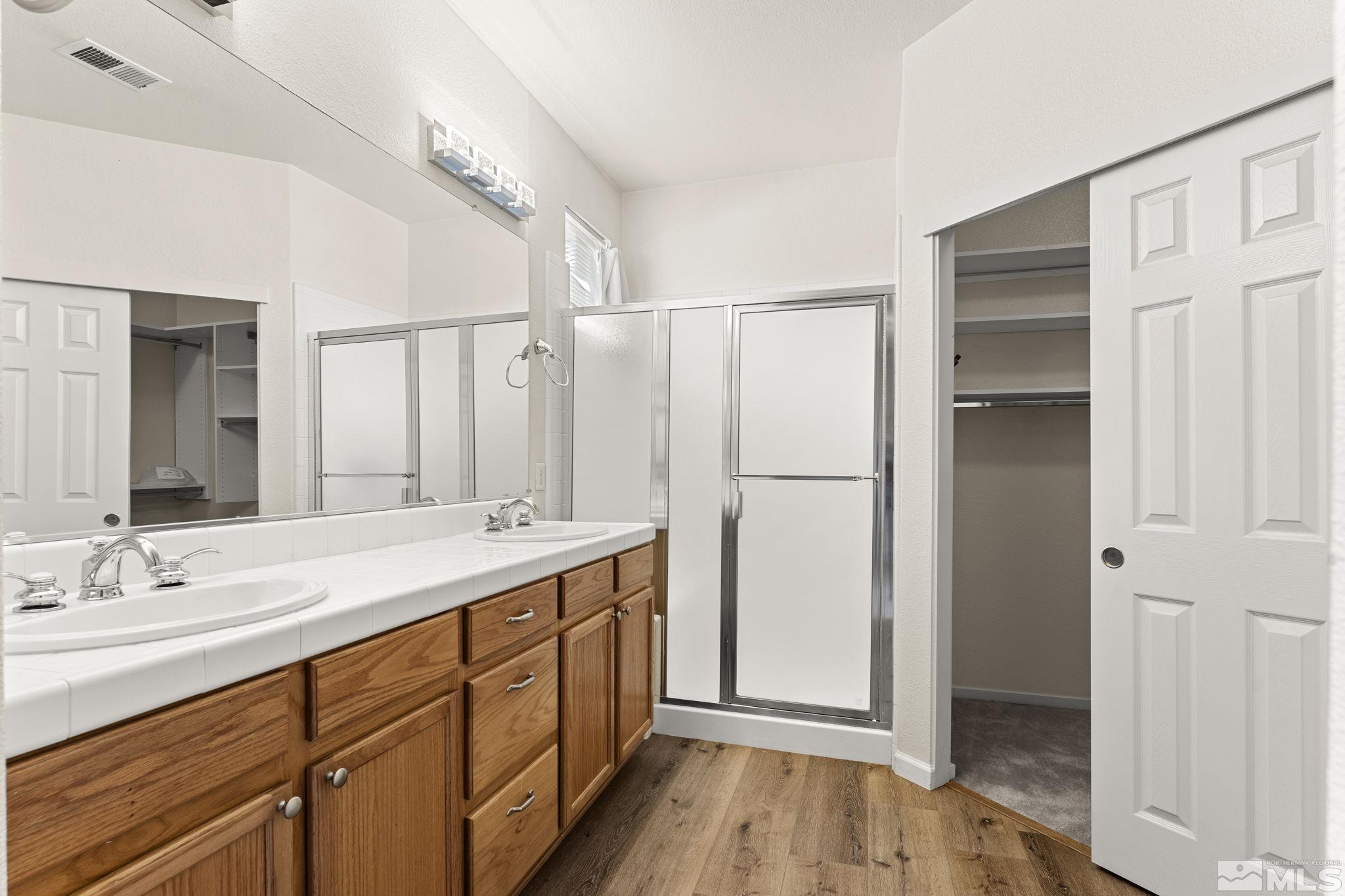 1436 Gaucho Lane Reno, NV 89521 - Photo 9 of 40 a spacious bathroom with a double vanity sink and a mirror