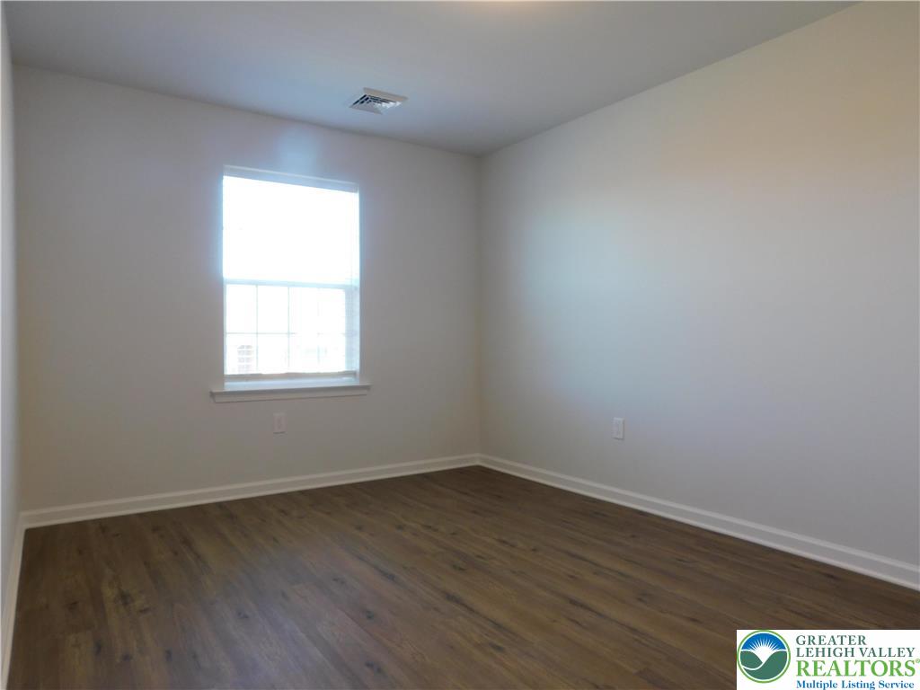 6645 Stein Way, Unit 66396661 Lower Macungie Township, PA 18062 - Photo 16 of 20 an empty room with wooden floor and windows