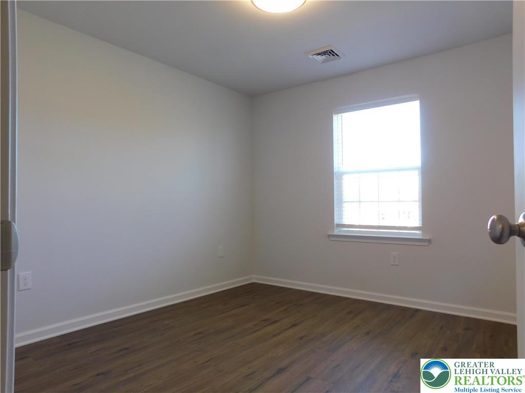 6645 Stein Way, Unit 66396661 Lower Macungie Township, PA 18062 - Photo 18 of 20 an empty room with wooden floor and windows