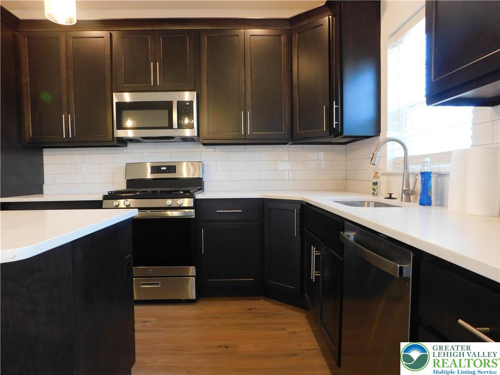 6645 Stein Way, Unit 66396661 Lower Macungie Township, PA 18062 - Photo 8 of 20 a kitchen with a sink a stove and microwave