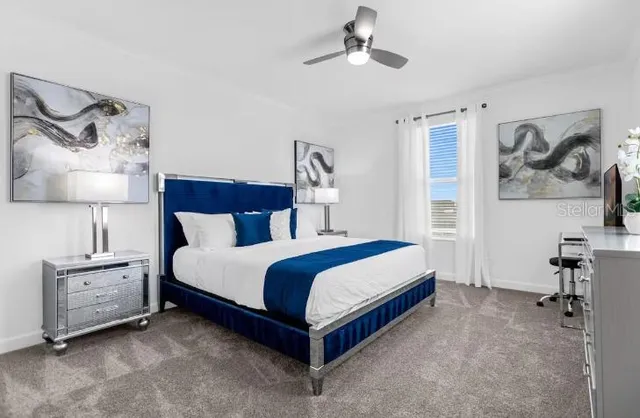 a bedroom with a bed and a lamp on the dresser