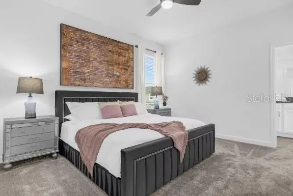 a bedroom with a bed a mirror and lamp