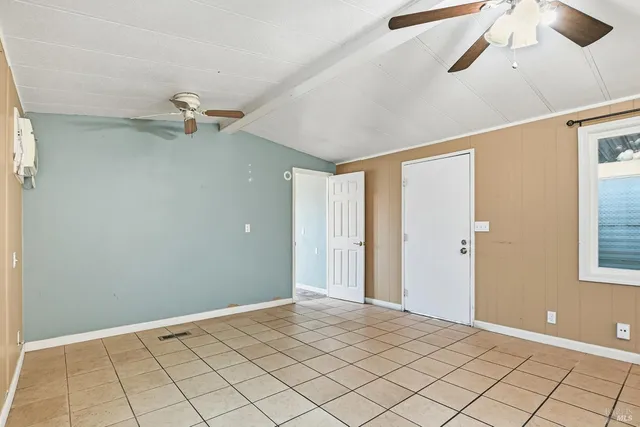 a view of a livingroom with a chandelier fan and windows